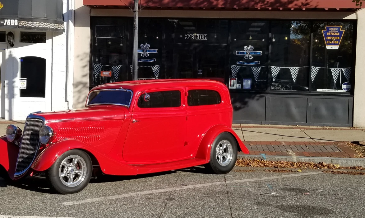 Red classic car in front of miller mountain high performance shop